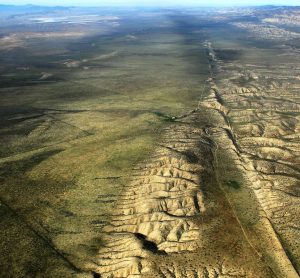 Aerial photo of a mostly green landscape with a linear mountain chain running from foreground to background.