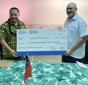 Aholotu Palu (right), CEO of Pacific Catastrophe Risk Insurance Company, hands the check to Lautimuia Afoa Vaai (left), Samoa’s Minister of Finance. Credit: Photo courtesy of PCRIC