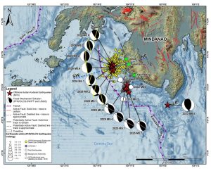 Figure 1. Seismotectonic map of the earthquake swarms. We show the locations of the 2023 magnitude 6.8, 2002 magnitude 6.8, 1976 magnitude 8.1, and 1918 magnitude 8.3 earthquakes. The aftershock area related to the 1976 magnitude 8.1 Moro Gulf Earthquake (Badillo and Astilla, 1978) is also plotted in this map as a dashed gray ellipse. The blue dashed line projects the location of the cross-section in Figure 3. Solid lines projected on the focal mechanism solutions or beachballs (red line for the 2023 magnitude 6.8 earthquake; gray line for the 2025 Palimbang earthquake swarm; and yellow line for the 2026 Kalamansig earthquake swarm) emphasize the trend of the east-dipping fault planes. Data sources: Earthquake locations from DOST-PHIVOLCS and ISCGEM, focal mechanisms from DOST-PHIVOLCS SWIFT-CMT catalog (Bonita et al., 2025), location of active faults, potentially active faults, and trenches from DOST-PHIVOLCS, SAR-derived topography and bathymetry from NAMRIA. Credit: Llamas et al., 2026, CC BY-NC-ND 4.0