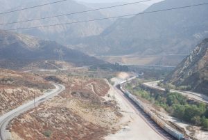 Cajon Pass is nestled between mountains and hosts high pressure gas lines, high voltage power lines, rail lines, fiber optics, water lines and Interstate 15. The San Andreas Fault runs roughly side to side across the center of this image. Credit: USGS, public domain